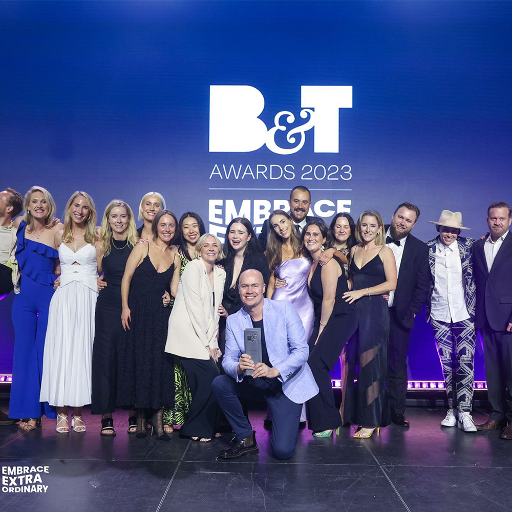 An image of a group of people in formal attire standing on stage at an awards ceremony.