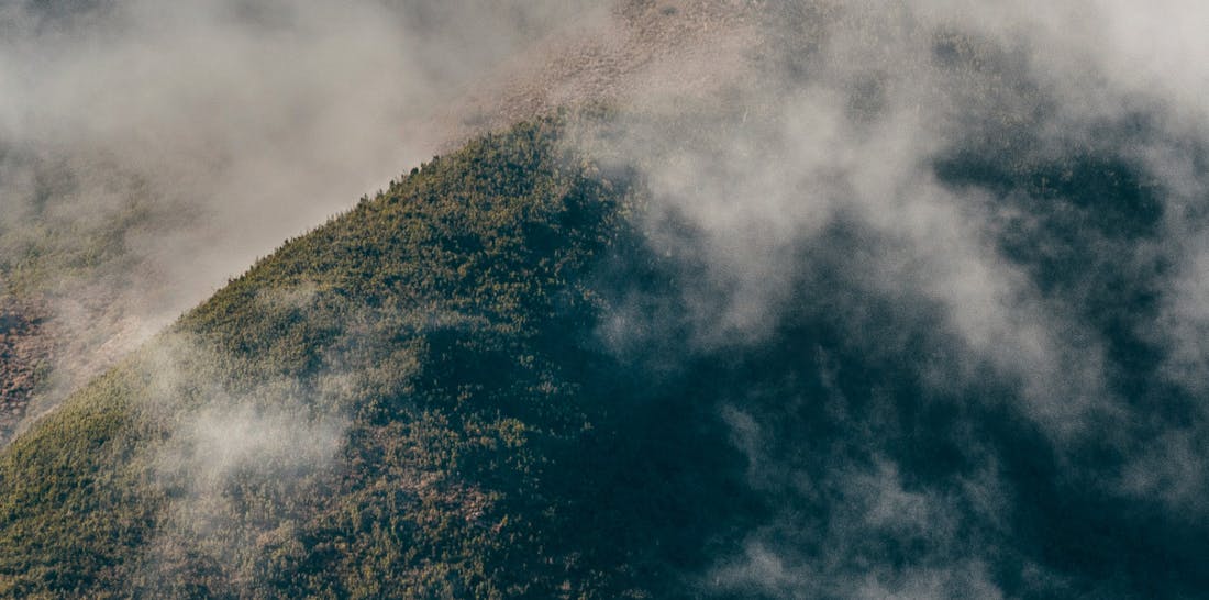 An image of a Tasmanian mountain peak shrouded in clouds.