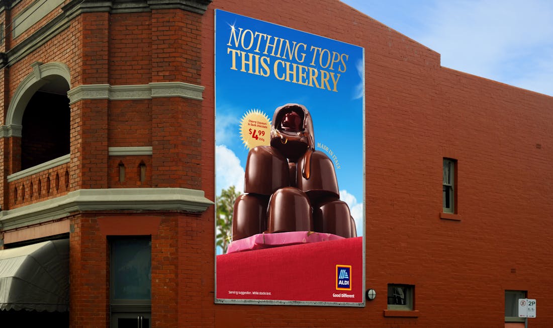 An image of a billboard on the side of a building. The ALDI logo and the words "Nothing tops this cherry" are overlaid on the image. 