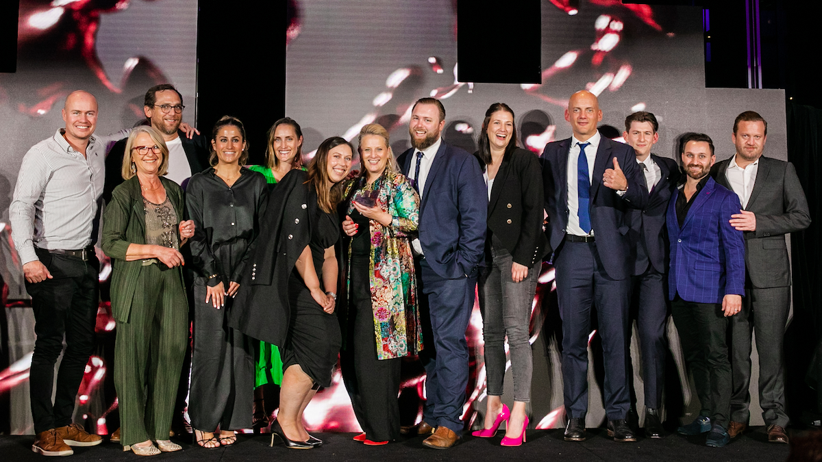 A group of cheerful people on stage at an awards event.