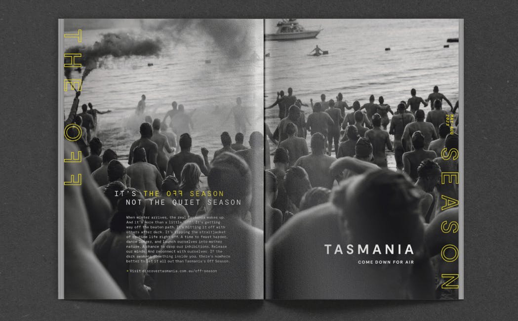 A magazine spread for Tourism Tasmania featuring a black and white image of people at the beach