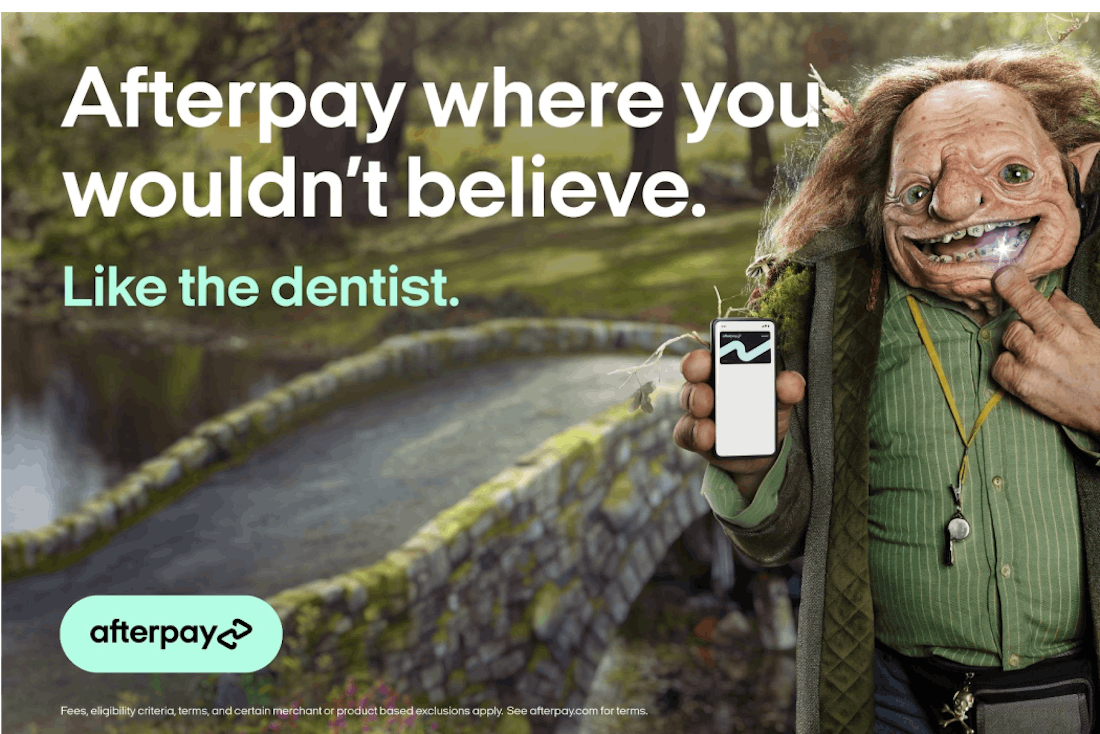 An image of a billboard, featuring a troll smiling at the camera holding a phone. The words "Afterpay where you wouldn't believe. Like the dentist" and the Afterpay logo are superimposed.