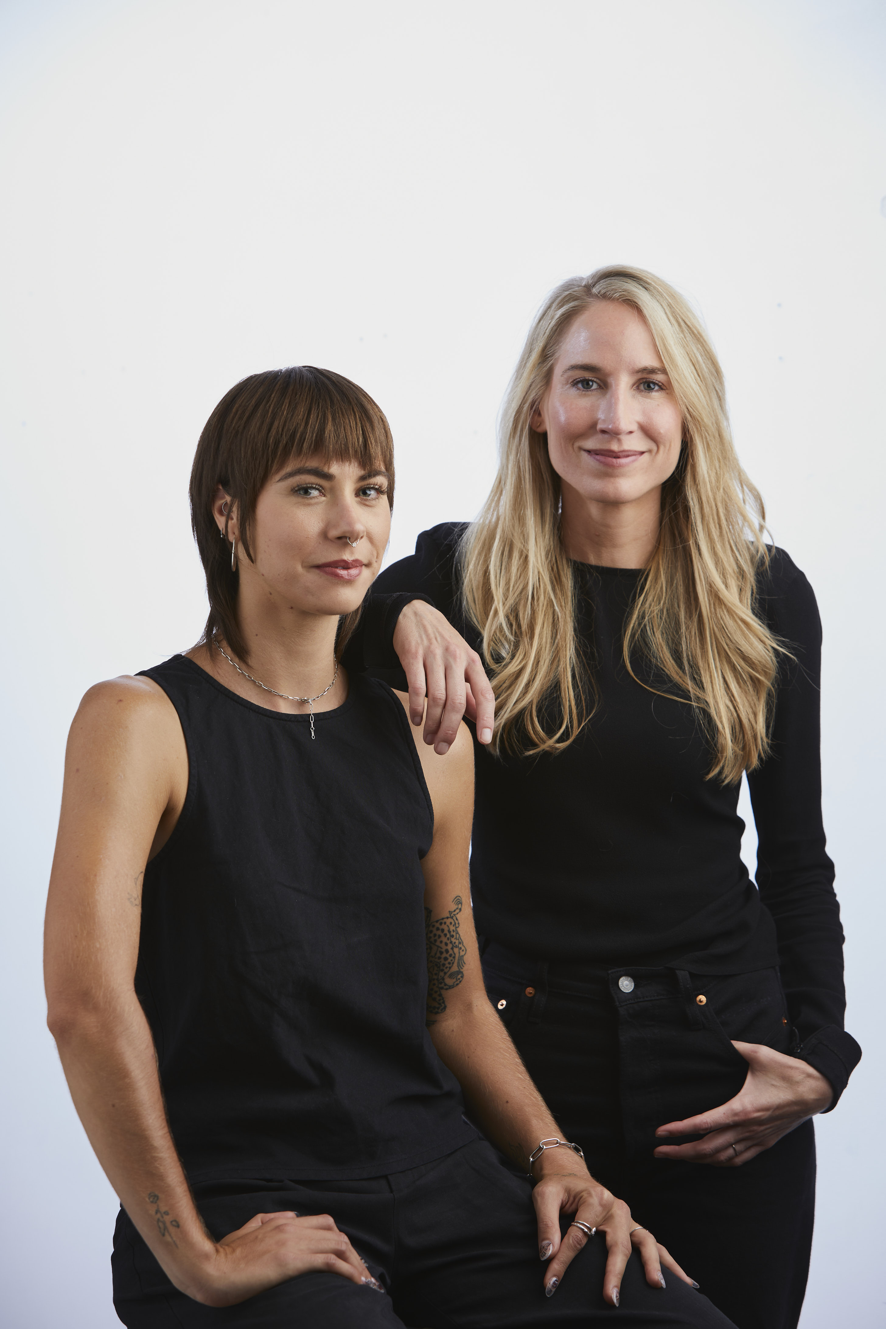 A portrait image of two women wearing black.