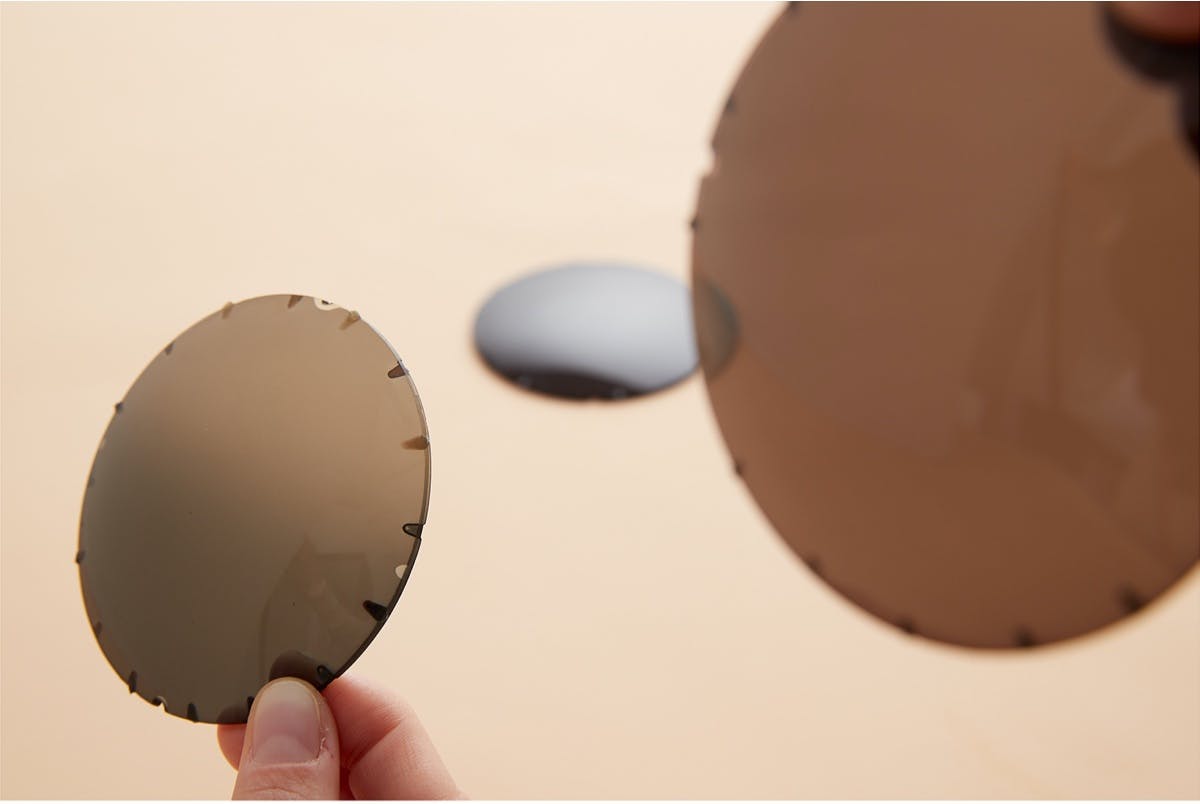 A hand holds up a polarized lens sample