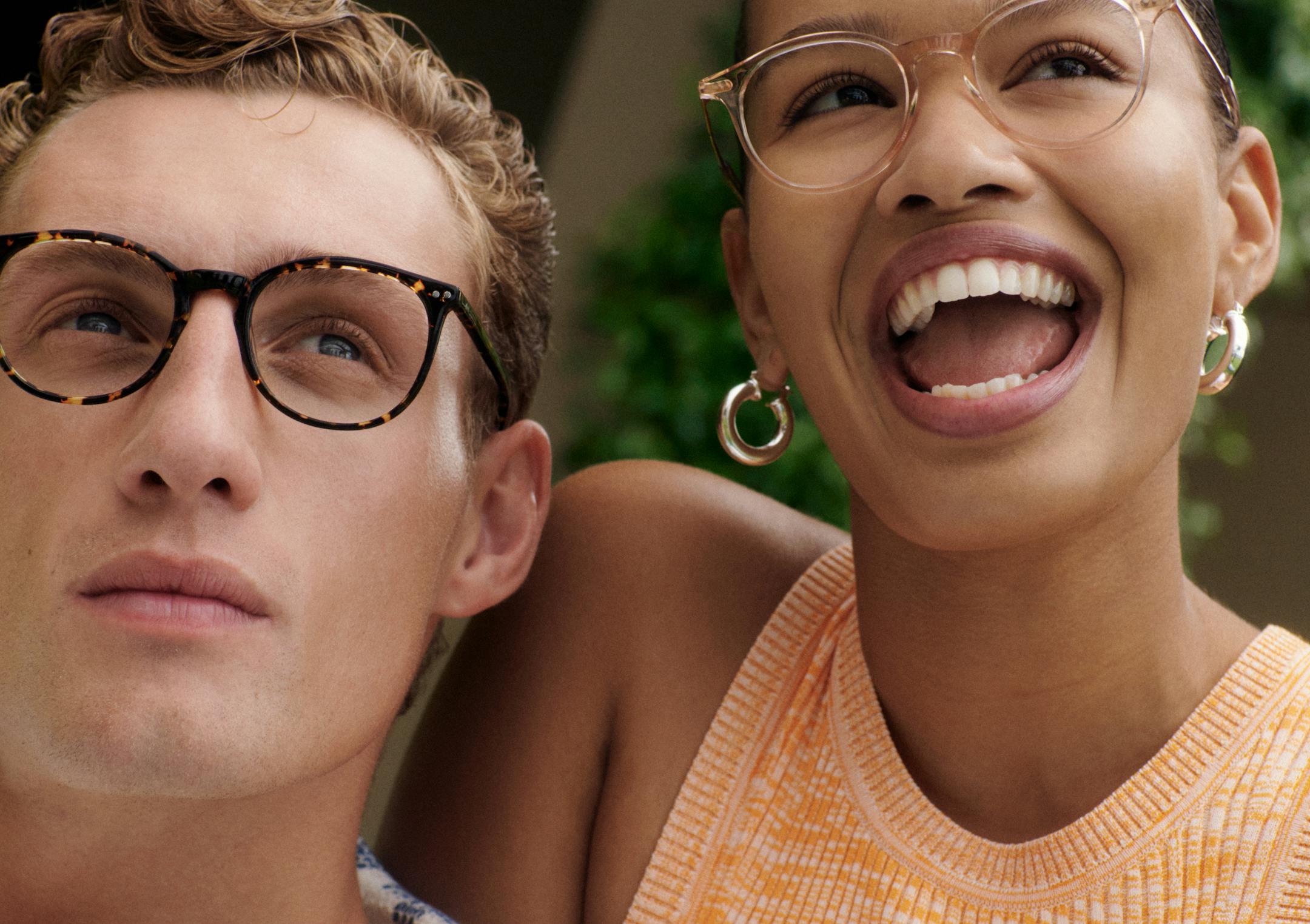 One person wearing round acetate tort Bailey Nelson glasses and another person smiling wearing round acetate pink Bailey Nelson glasses