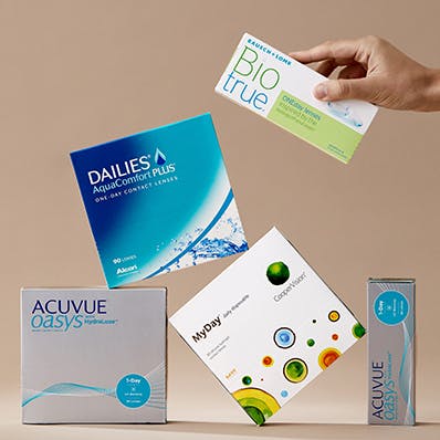 A stack of contact lens boxes from Acuvue, Dailies, MyDay and BioTrue.