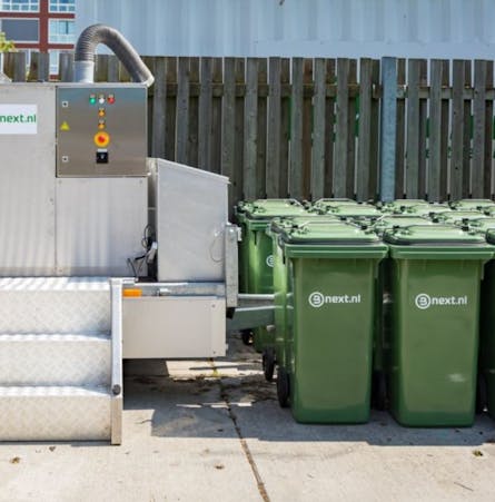 De composteermachine die op het terrein van de Jaarbeurs in Utrecht staat met rolcontainers ernaast