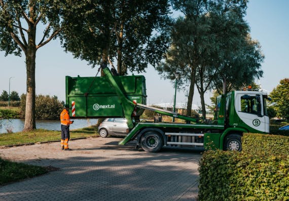 Bnext.nl medewerker haalt een gesloten 9 kuubs container op bij een woonhuis in Alphen aan den Rijn