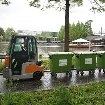 Vier rolcontainers achter een ophaalwagentje op de Campus in Eindhoven
