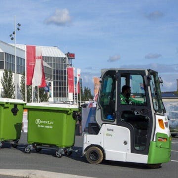 Ophaalwagentje met rolcontainers erachter op het terrein van RAI