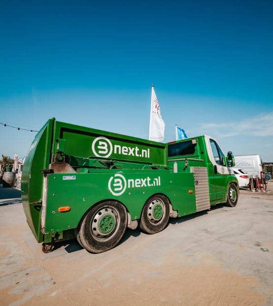 Een miniperswagen op het strand bij een klant