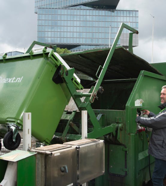 Bnext.nl medewerker leegt rolcontainer in een perscontainer