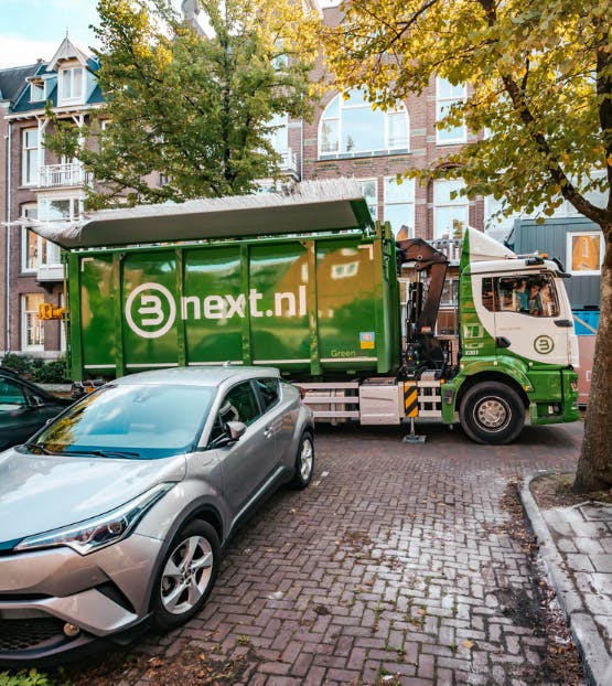 Een ophaalwagen in een drukke stadsstraat