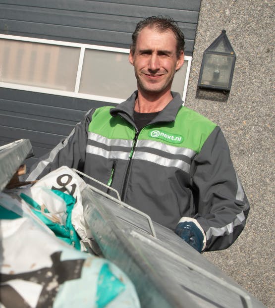 Chauffeur rolt afval naar zijn wagen