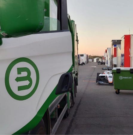 Bnext.nl wagen naast een raceauto op het circuit van Zandvoort