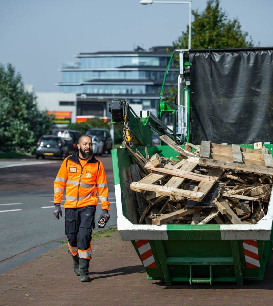 Container gevuld met afvalhout in een stedelijke omgeving