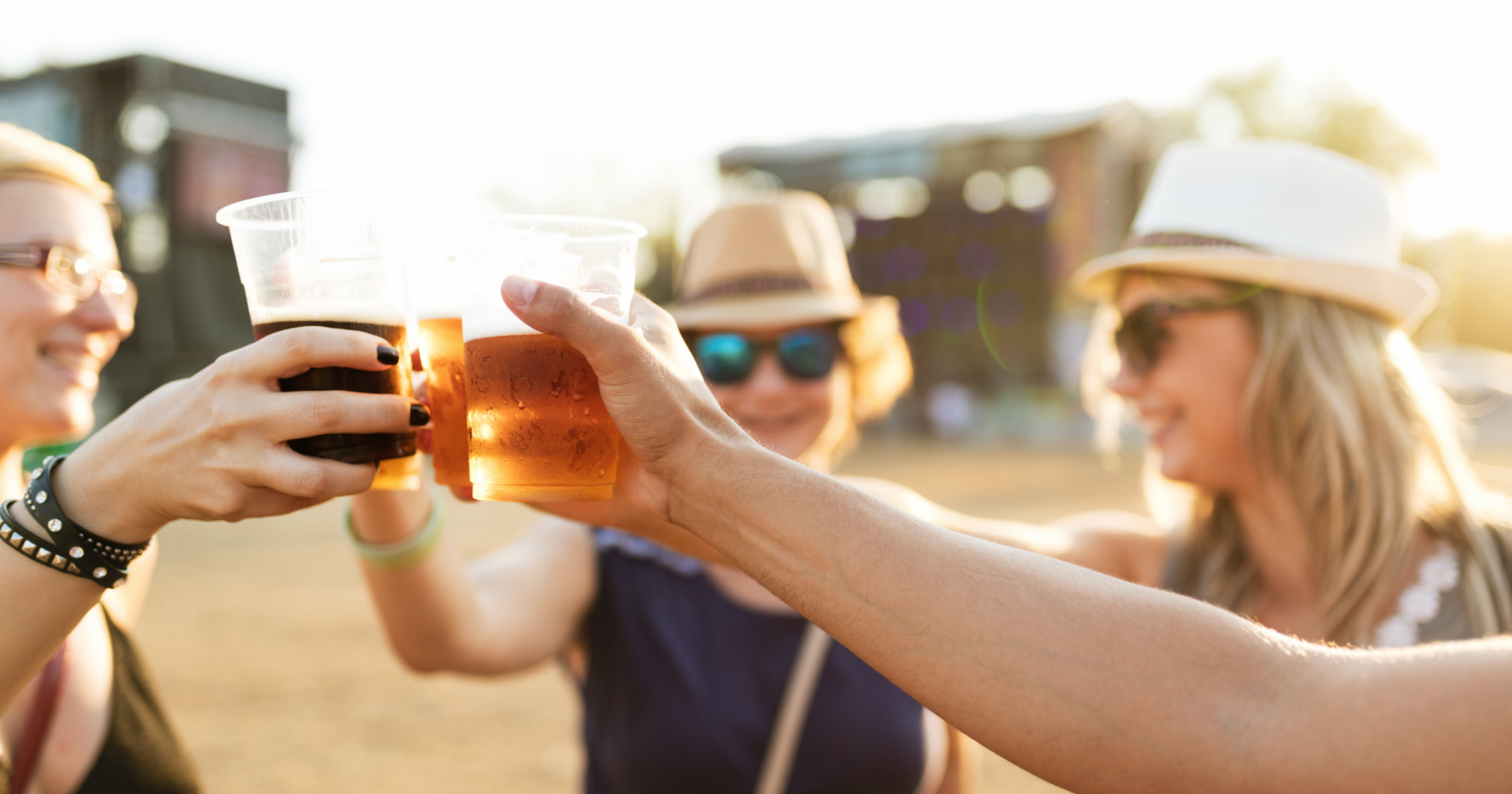 Bezoekers van een festival proosten met een plastic beker