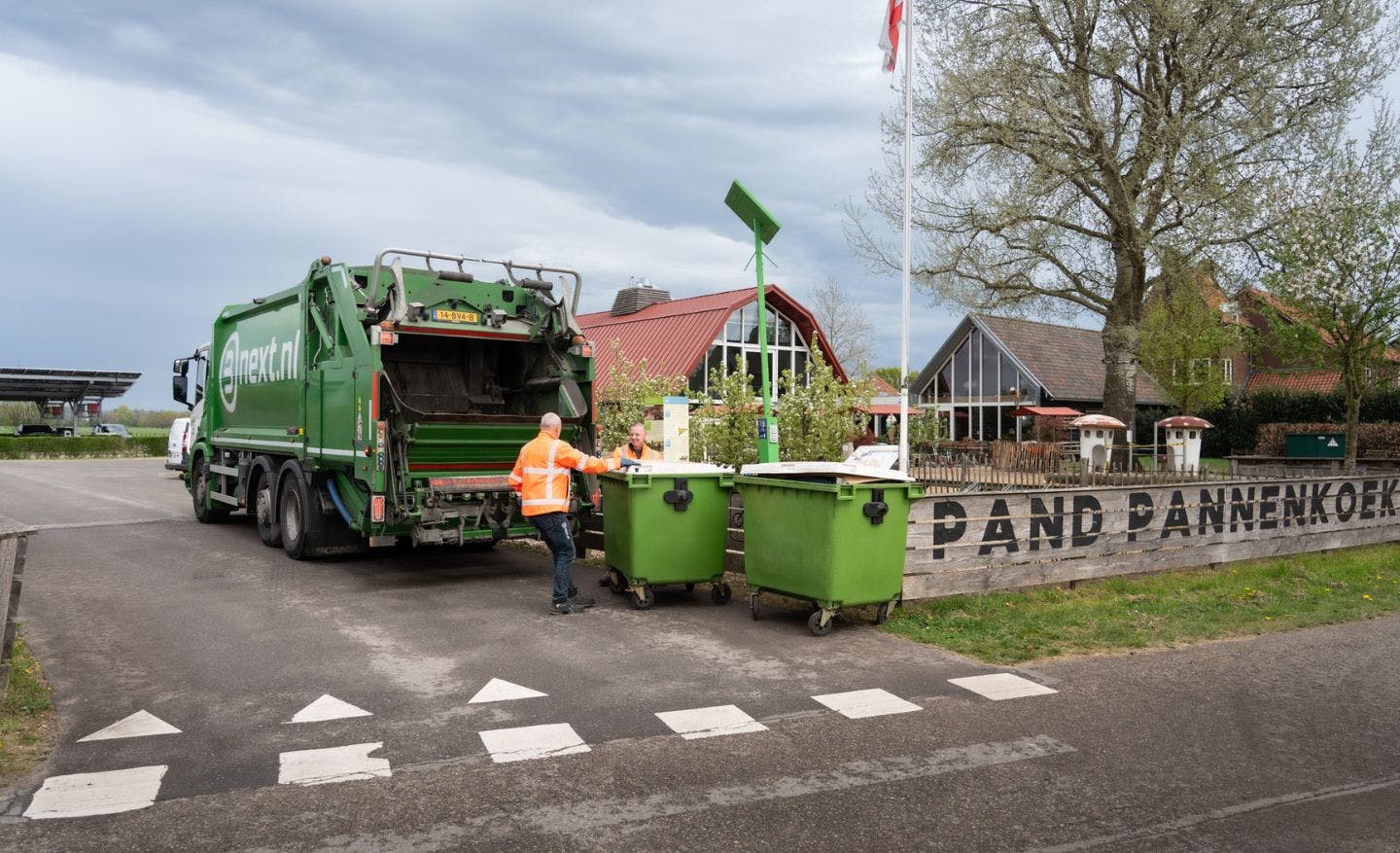 Kraakpersvrachtauto met rolcontainers bij horeca