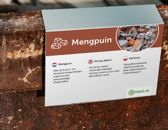 Een bordje over mengpuin op een container