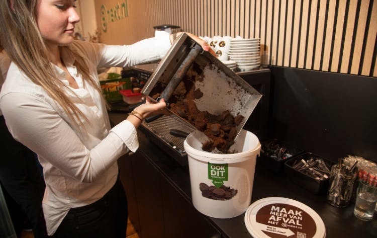 een vrouw zamelt koffiedroes apart in