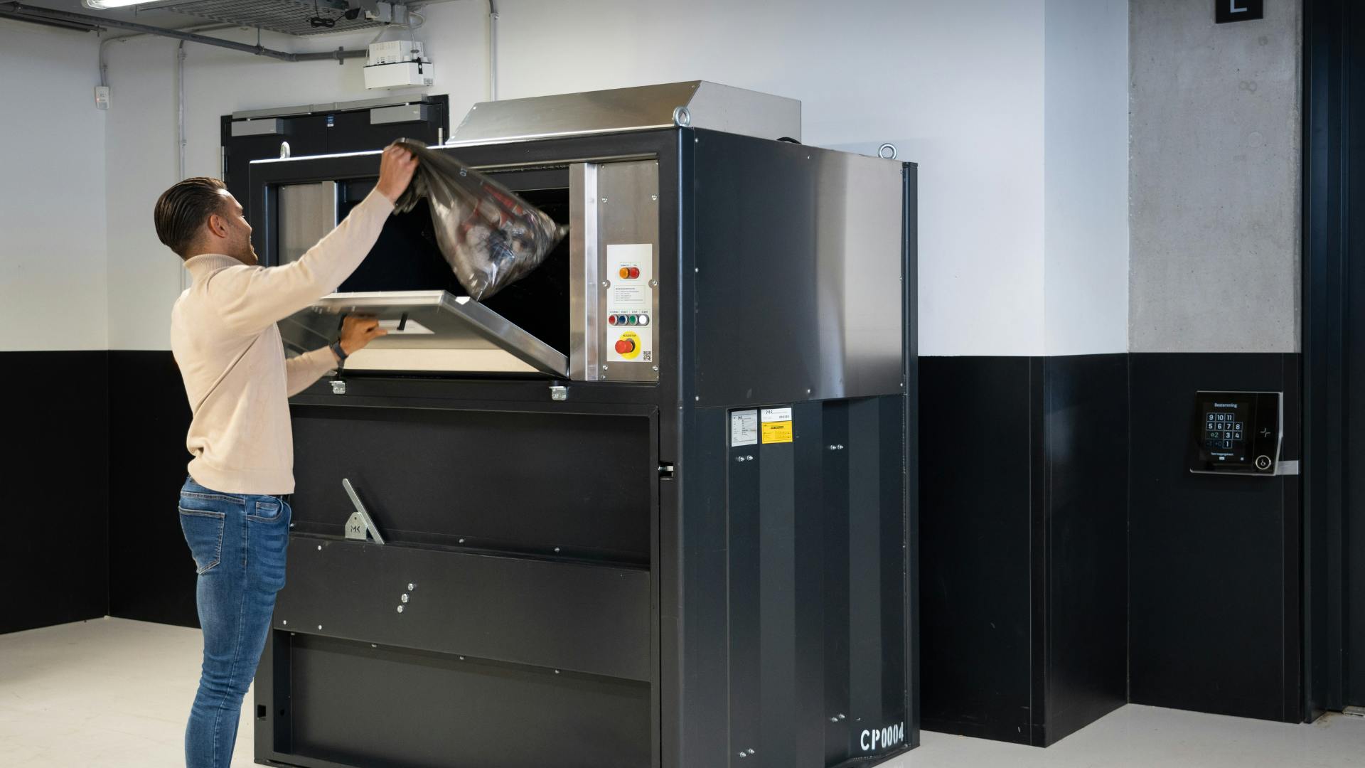 Vuilnis wordt in de Impress afvalpers geworpen