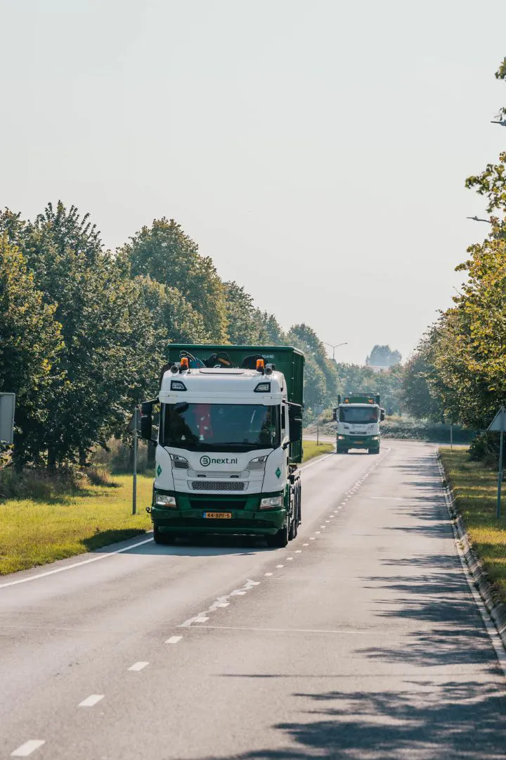 Bnext.nl vrachtwagens op de weg in een groene omgeving