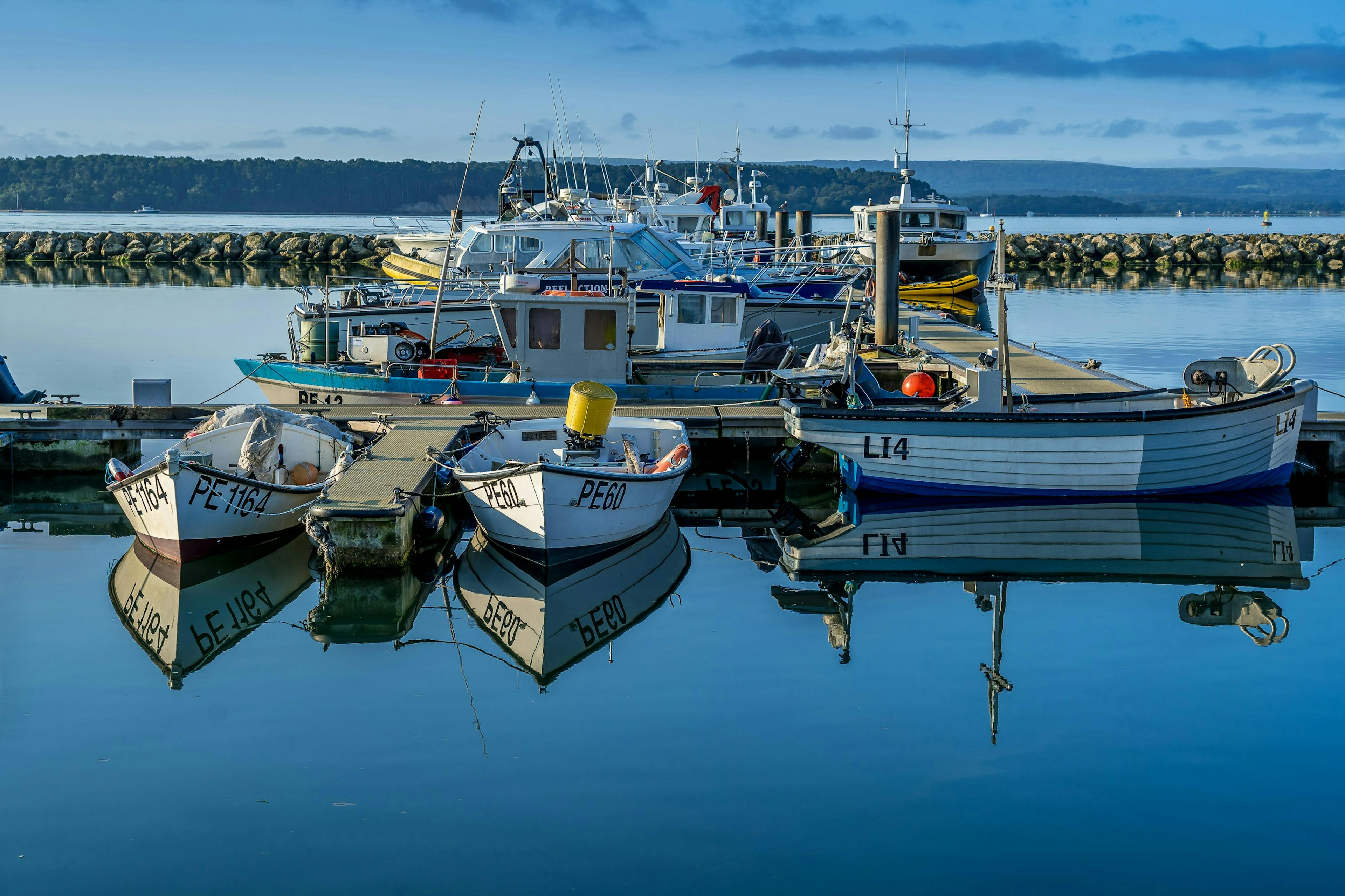 docked boats in the river shore during the blue hour. Navigating the Waters: A Guide to the Costs of Owning a Boat