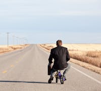 business man on a kids bike