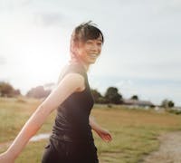 woman walking through a fiedl in the morning.