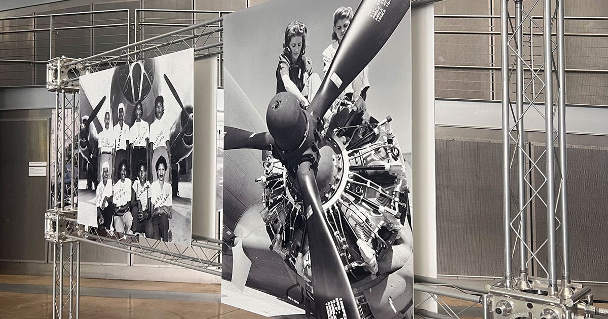 A snapshot of our new Rosie exhibit, featuring two iconic Rosie photos in black and white, hung on a metal truss.