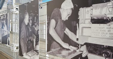 Scaffolding with large, black-and-white images of our 'Rosie's' hard-at-work in the Boeing factory, building airplane parts.