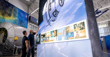 Guests view a section of our Gallery, which features big, bold imagery of the Boeing CST-100 Starliner, SLS, and more.