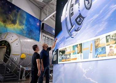 Guests view a section of our Gallery, which features big, bold imagery of the Boeing CST-100 Starliner, SLS, and more.