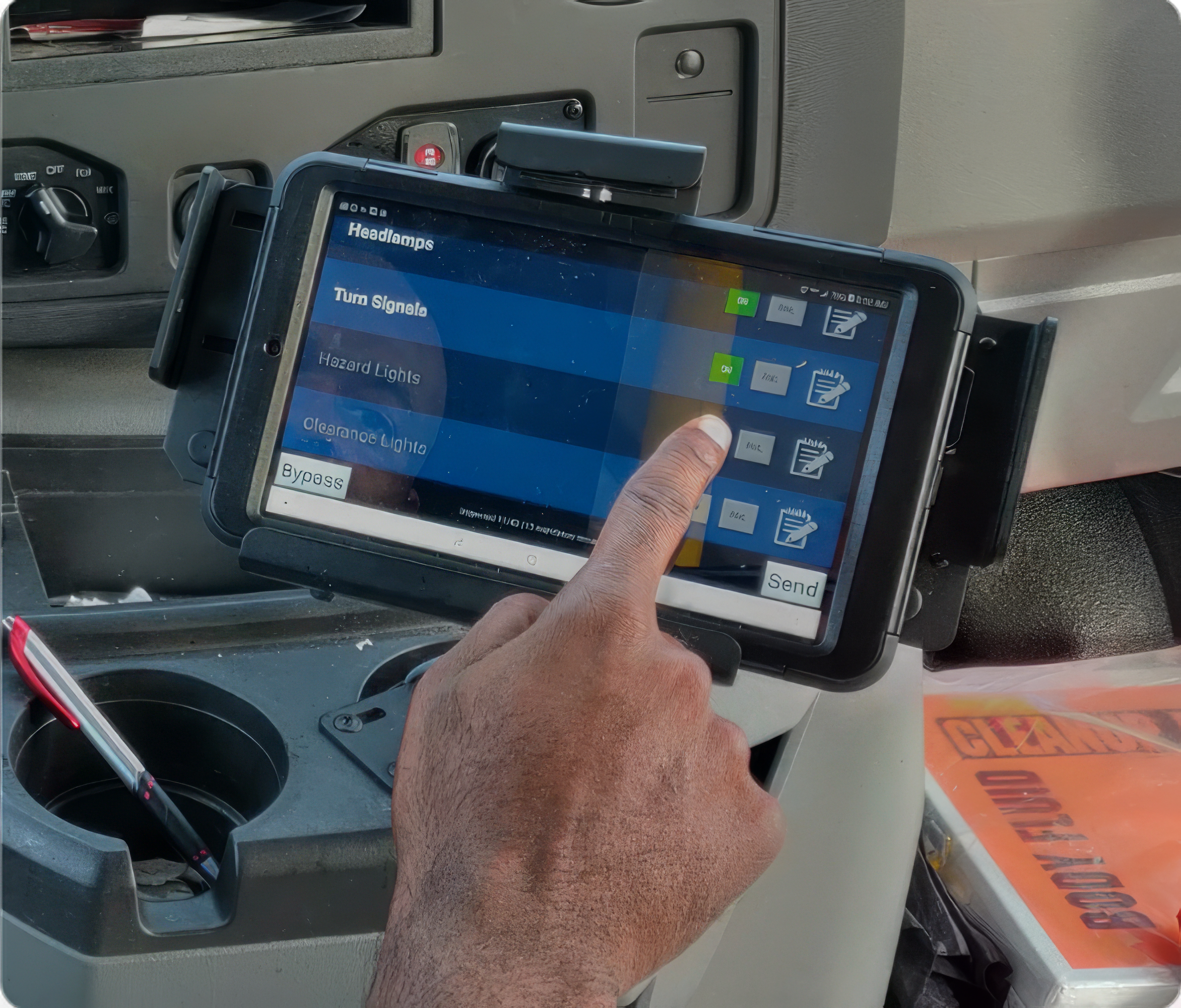 Driver uses a mounted tablet inside a vehicle to control operational settings, with on-screen buttons for lights and signals.