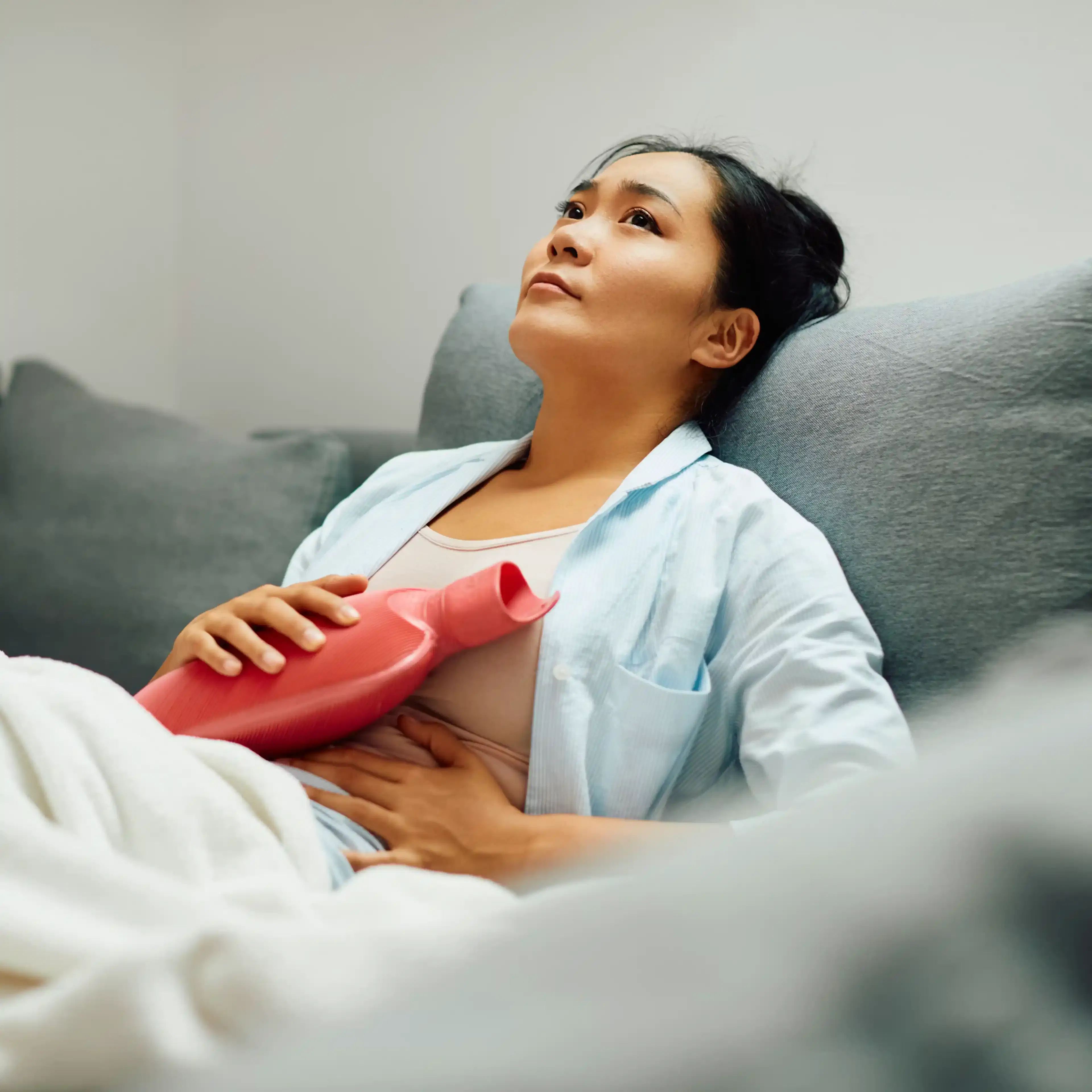 Femme avec bouillotte sur son ventre endométriose