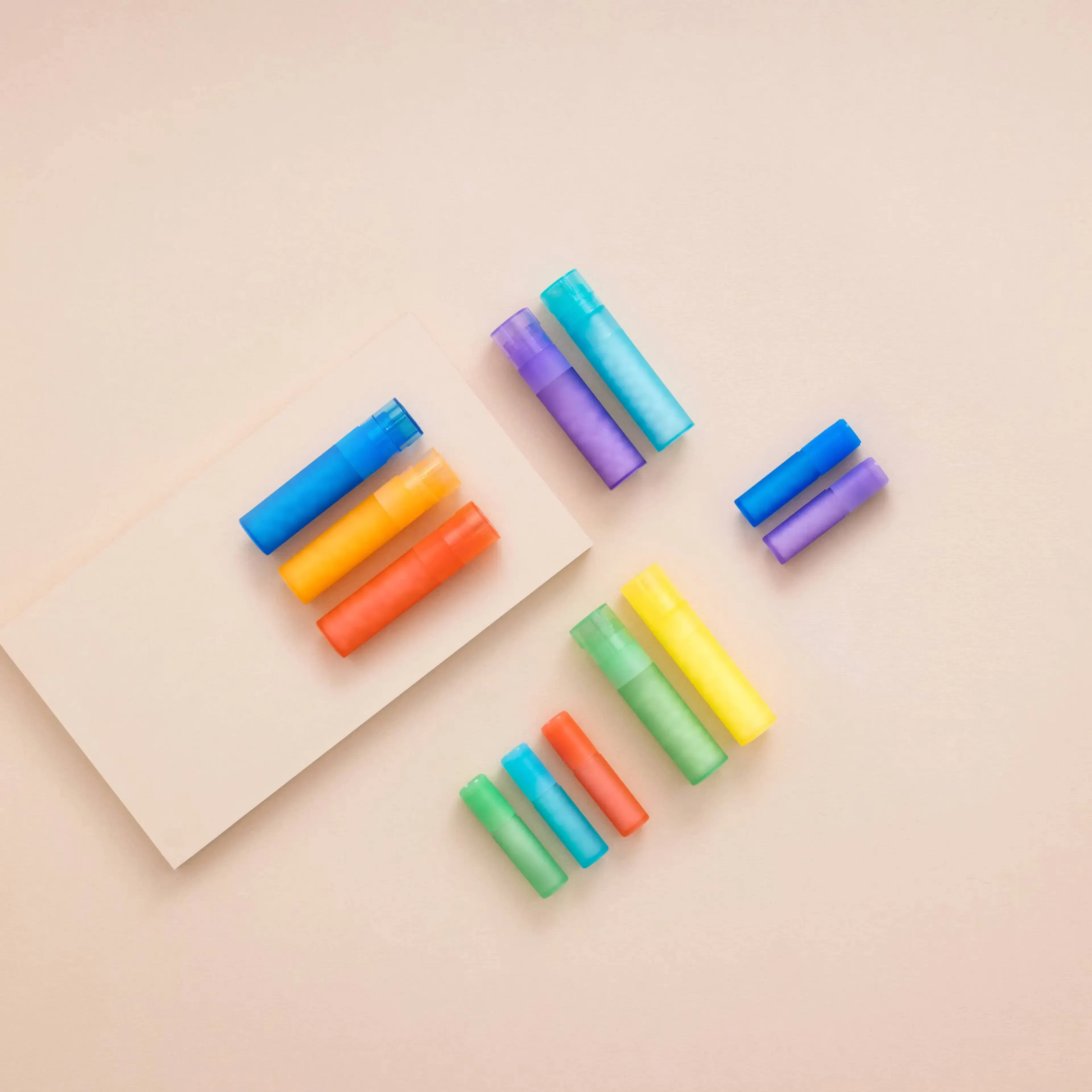 Tube homéopathiques de différentes couleurs sur un fond beige