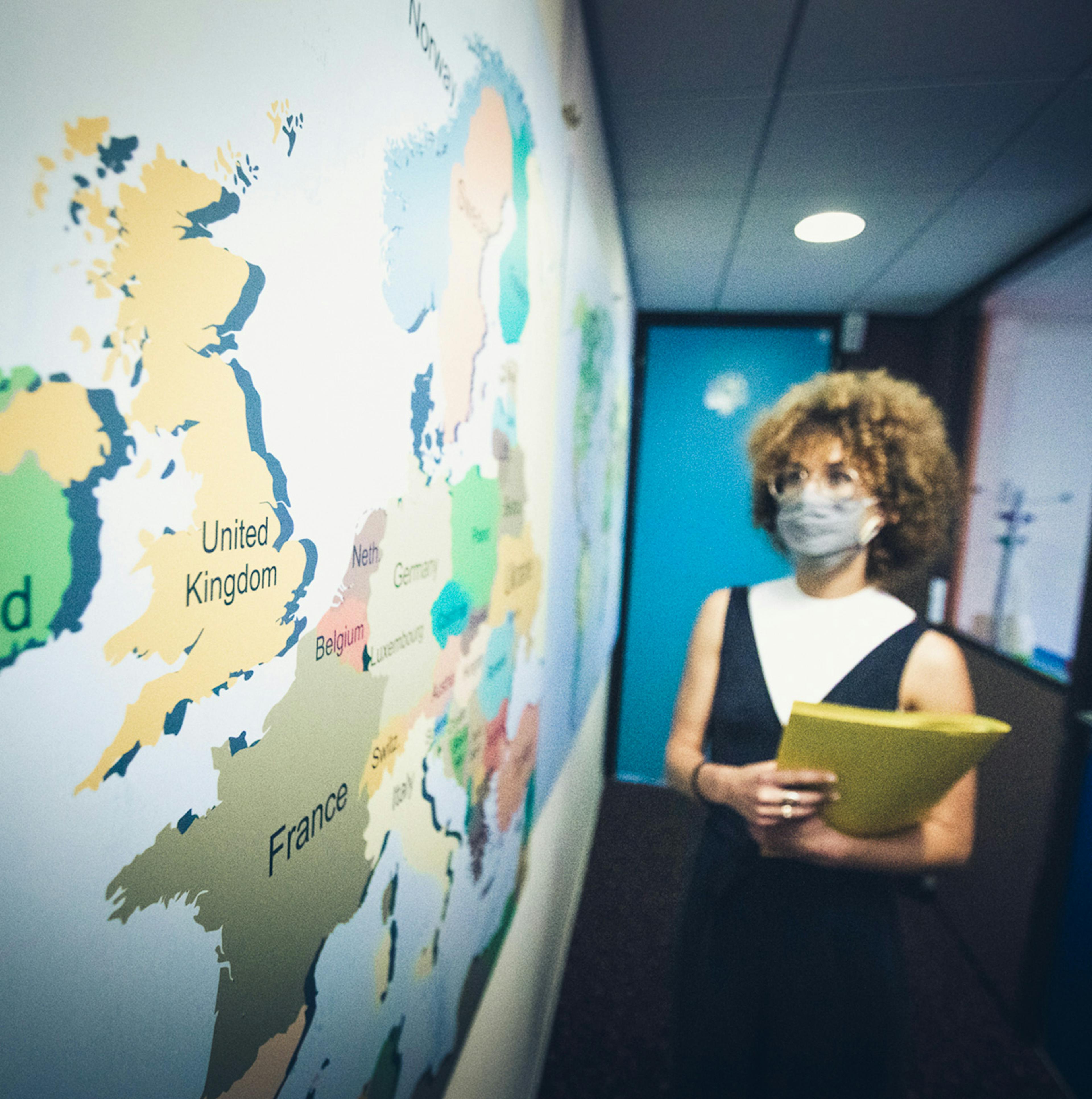 Mujer joven delante de un mapa del mundo