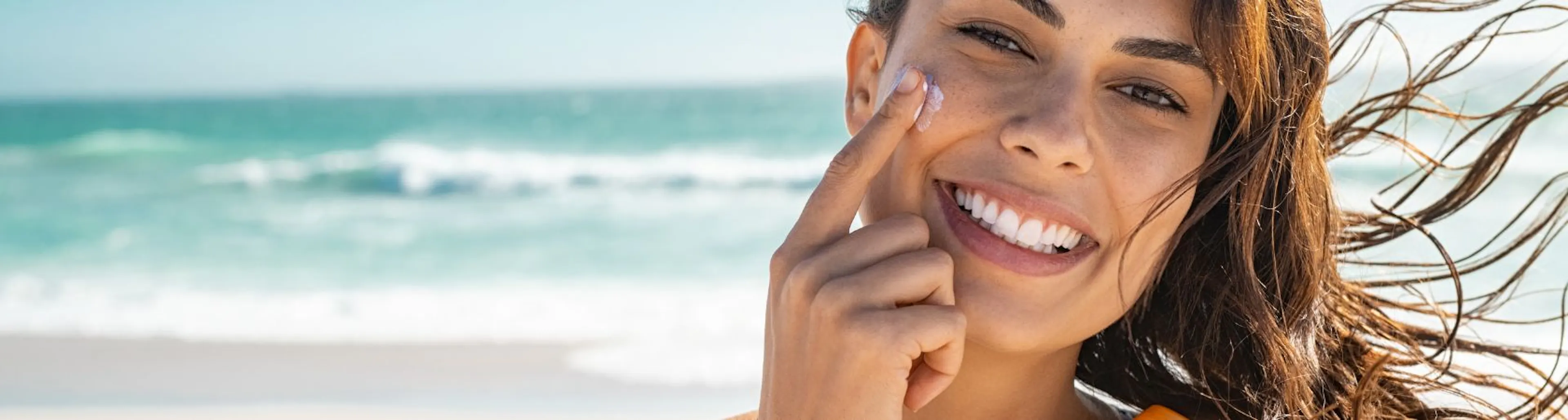 Femme appliquant des produits solaires pour préparer sa peau au soleil