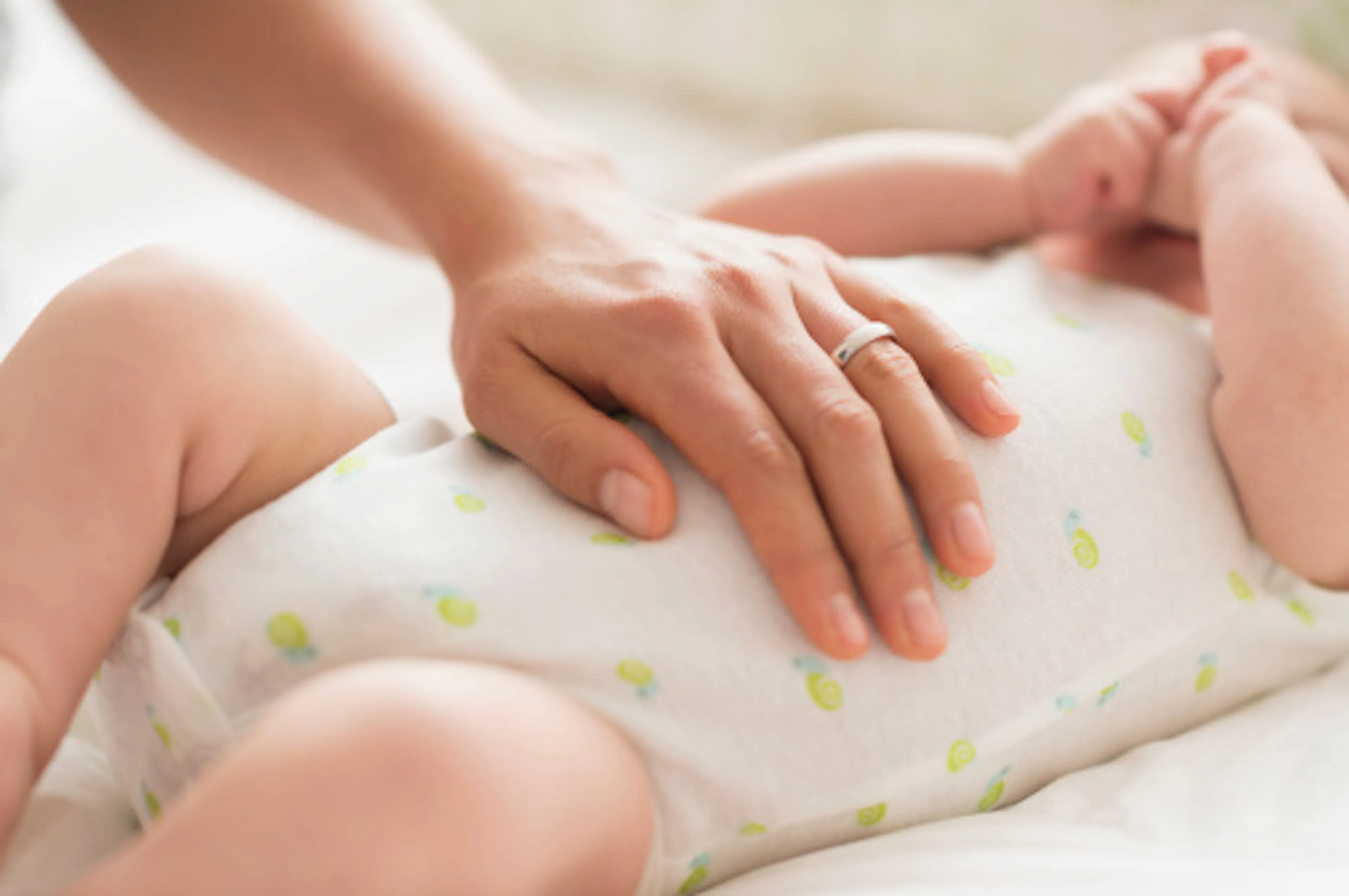 Mamma che accarezza il neonato con il reflusso