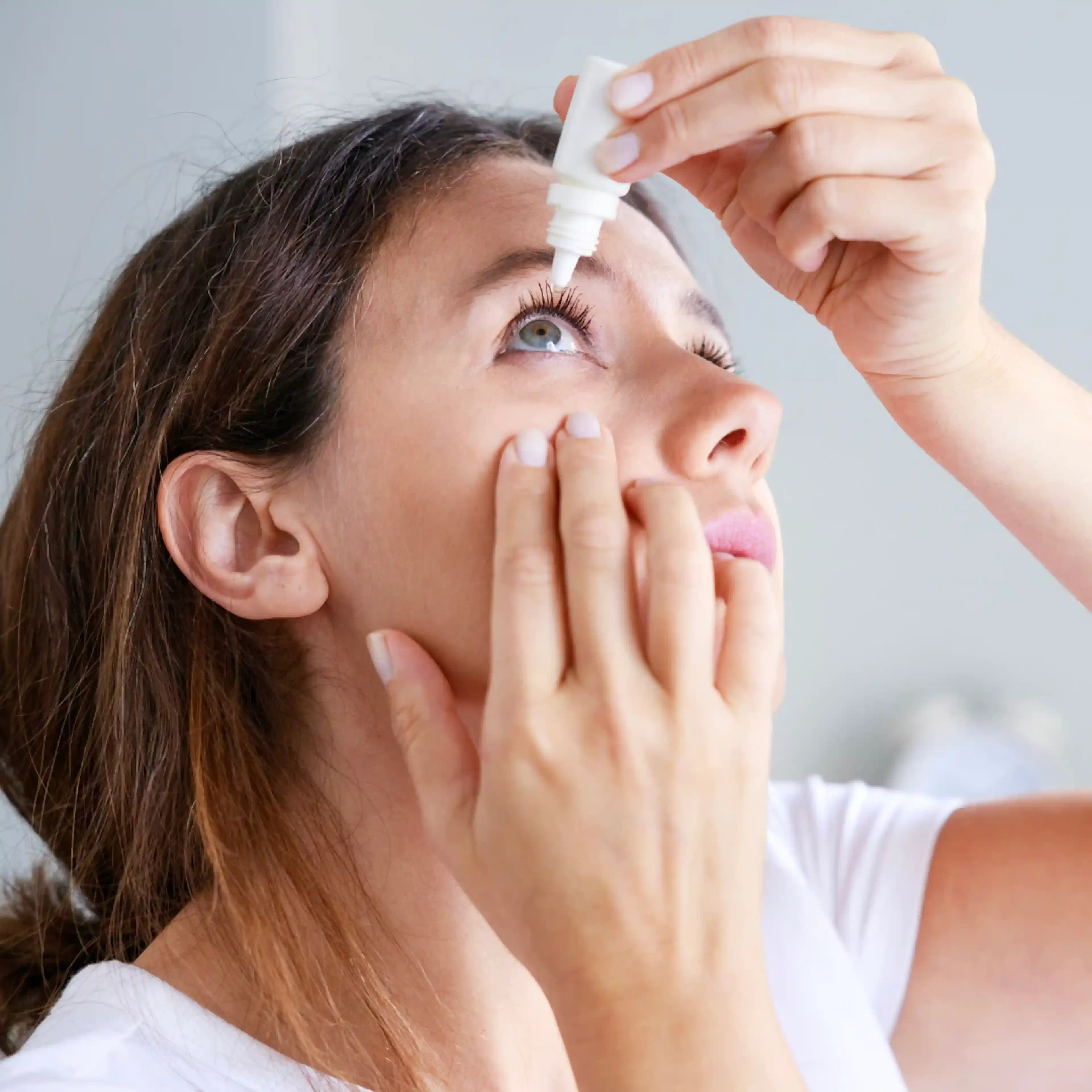 Femme se met des gouttes oculaires yeux secs