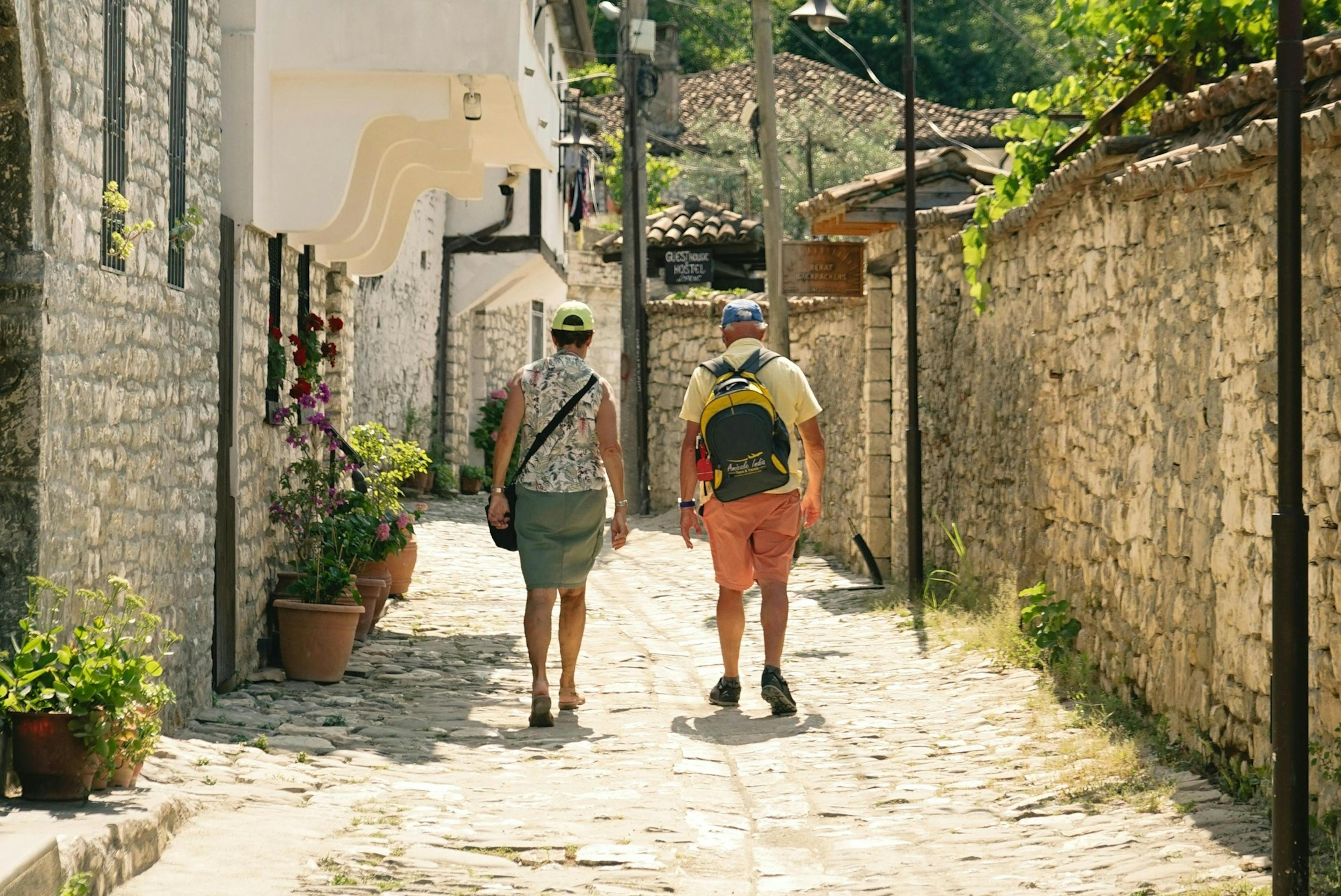 teplo, léto, dva starší lidé jsou po ulici ve městě, pohled zezadu