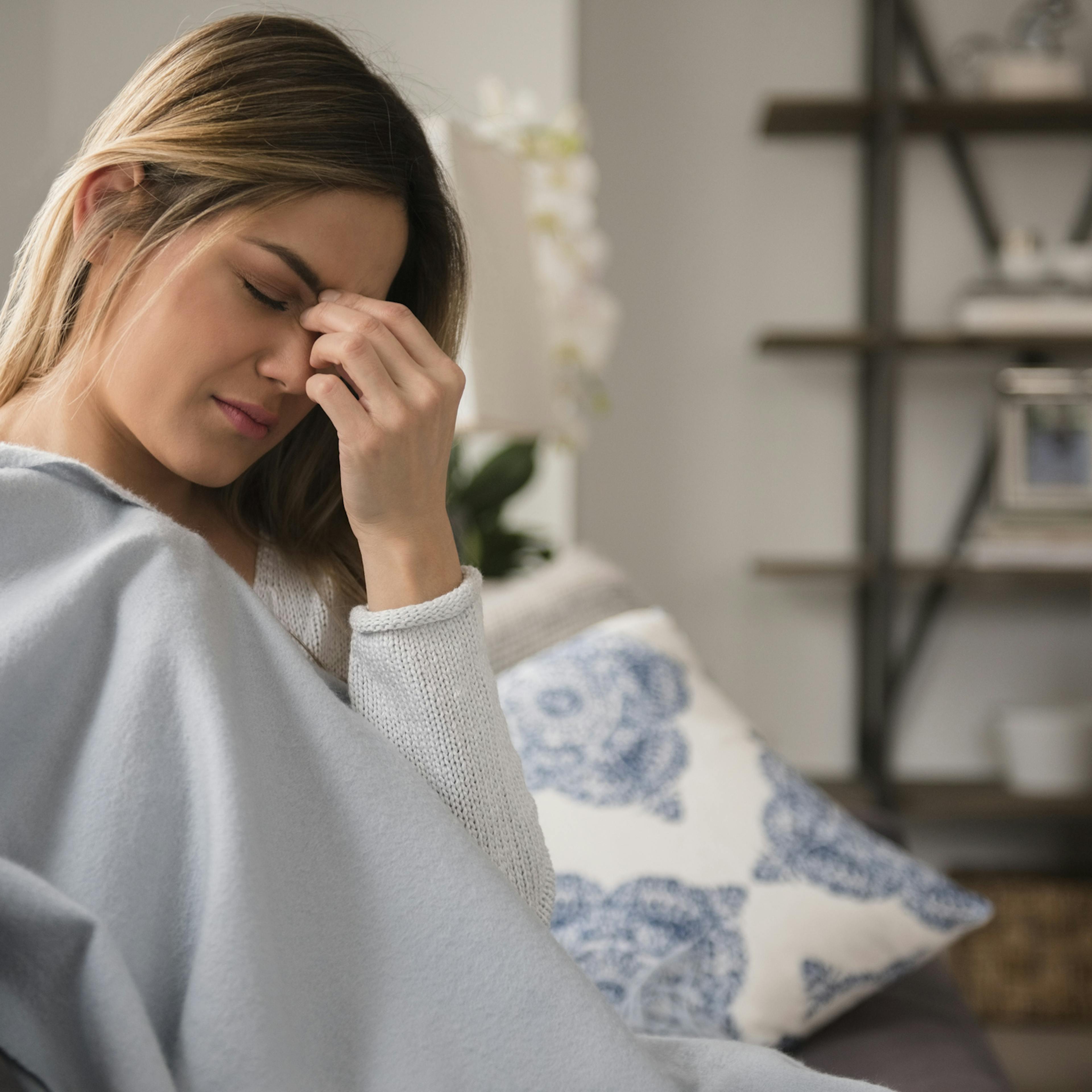 femme qui se tient le front à cause d'un mal de tête