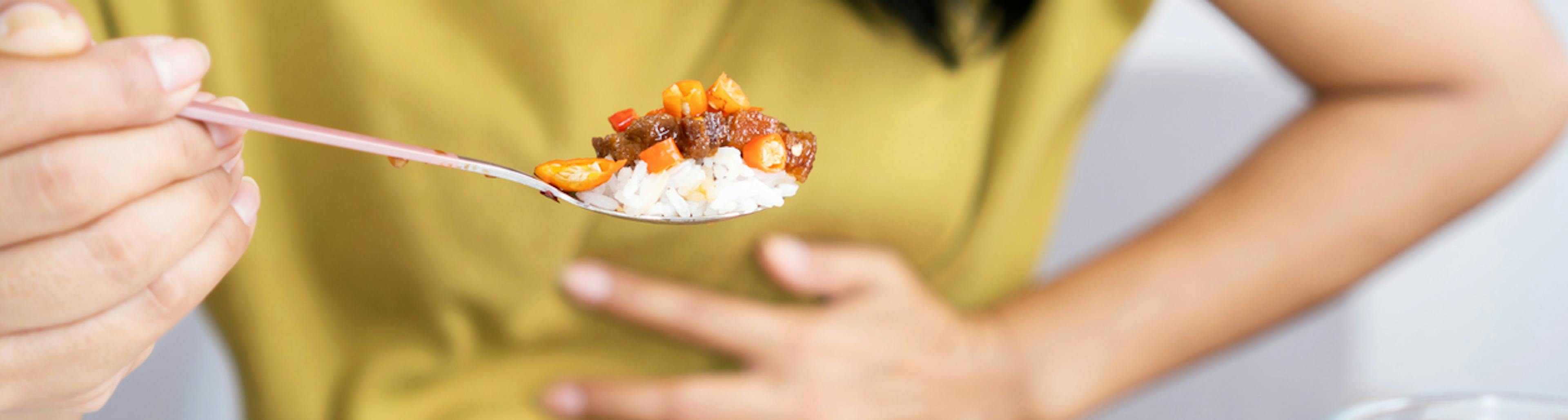 donna accusa i sintomi della cattiva digestione mentre mangia 