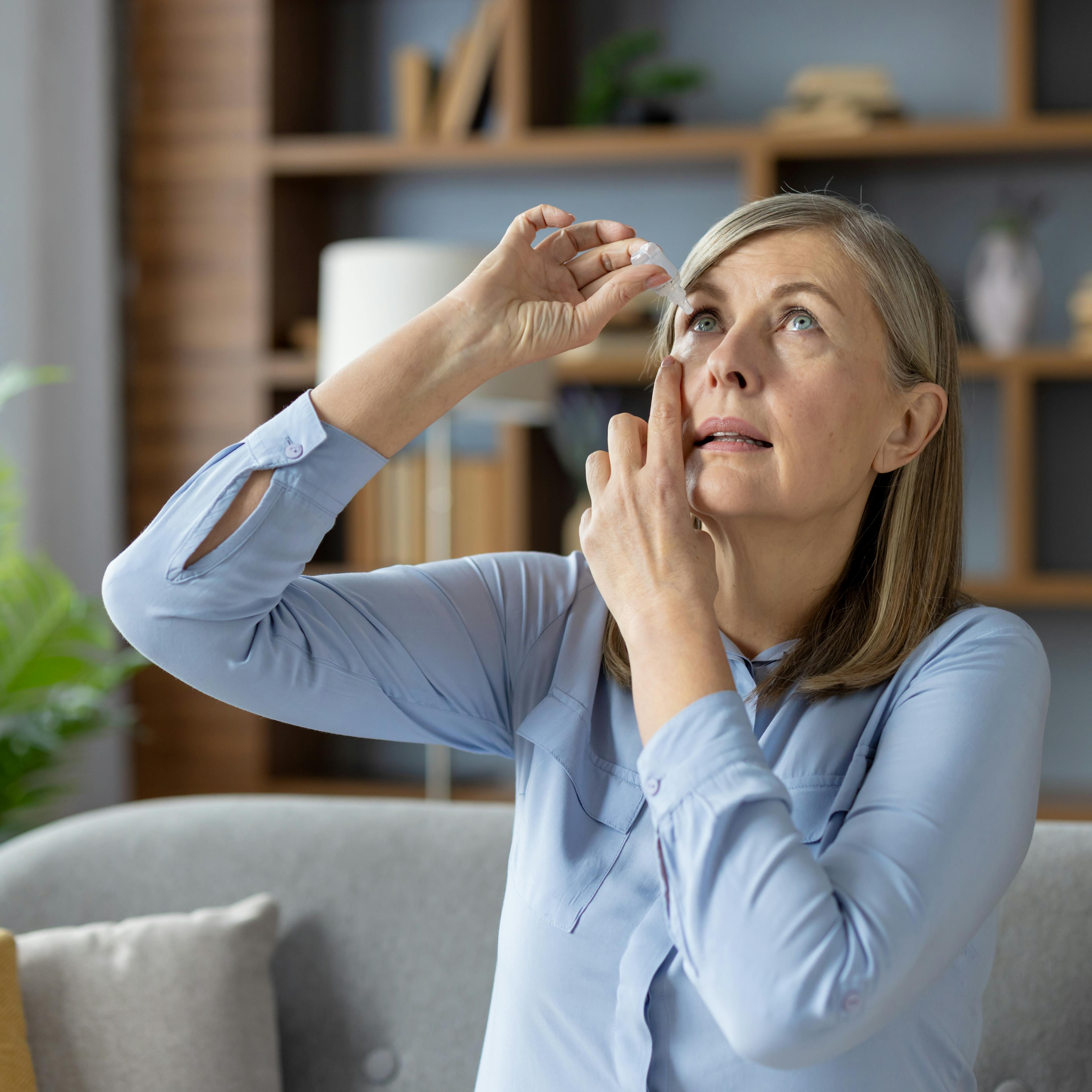 femme qui se met des gouttes oculaires dans l'œil yeux secs 