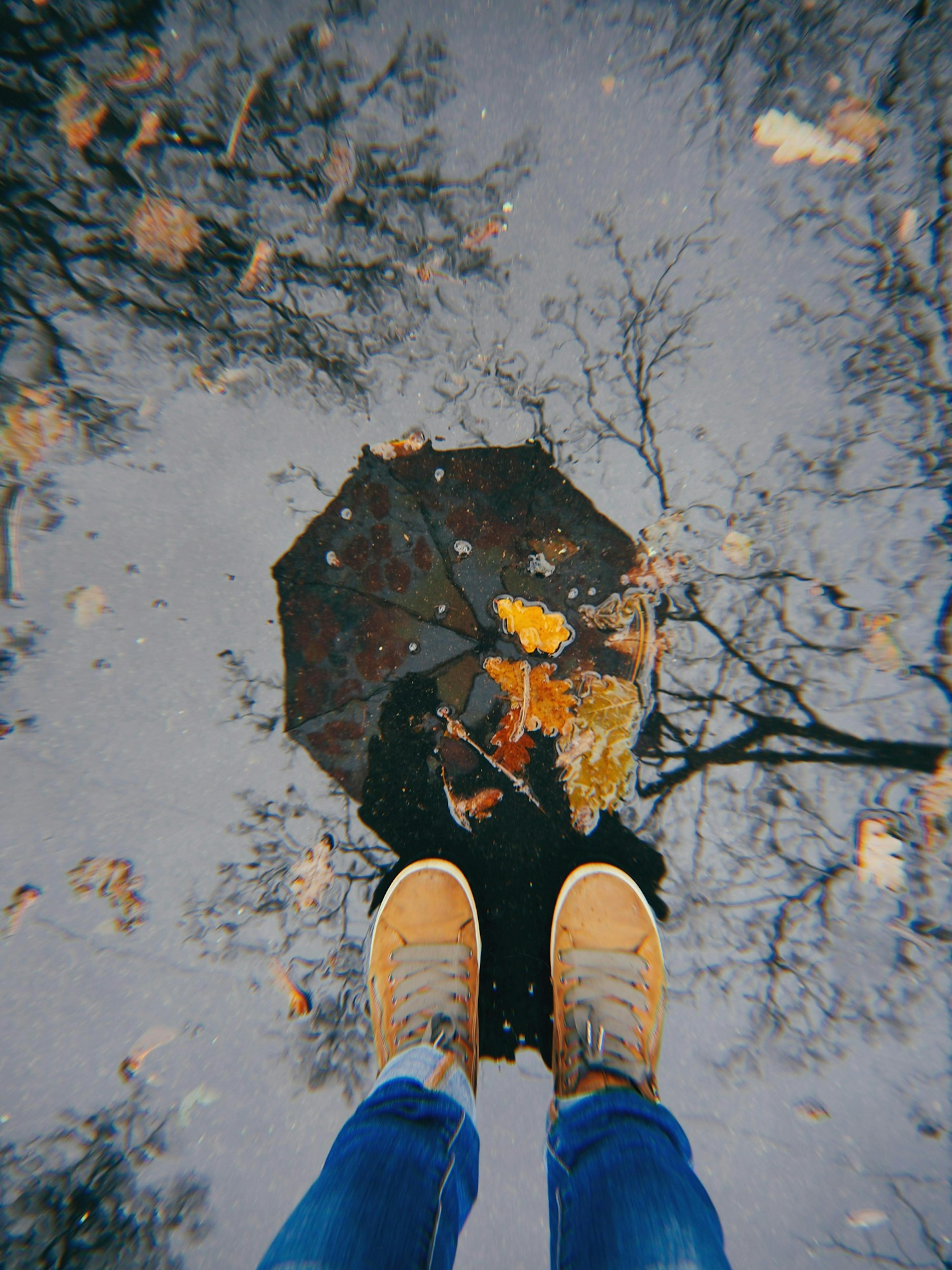 podzim, déšť, pohled shora na louži, boty, odraz deštníku