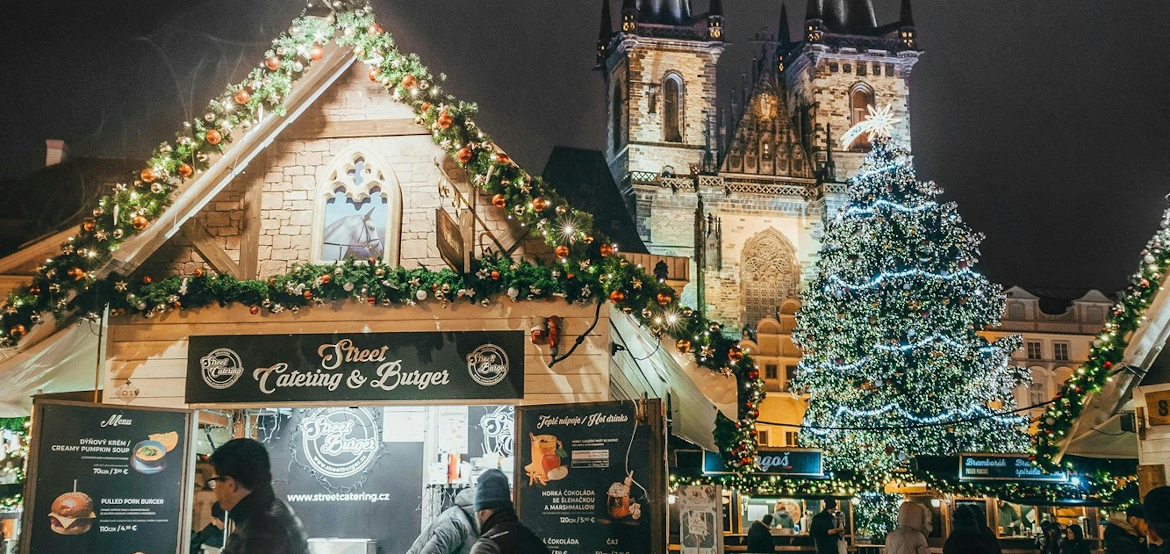 Vánoce, Staroměstské náměstí, ozdobený vánoční strom, stánky s občerstvením a lidé, večerní vánoční atmosféra