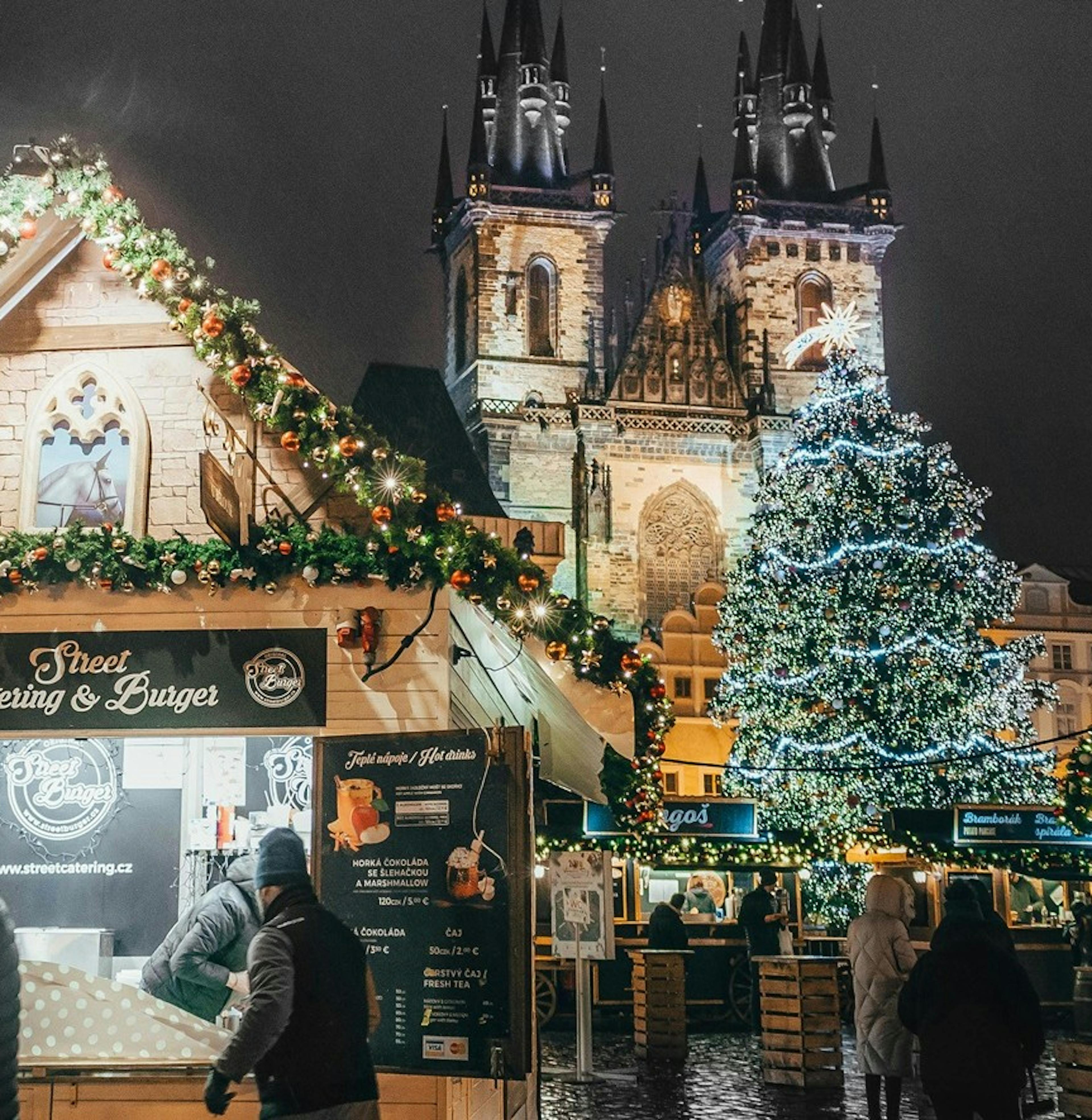 Vánoce, Staroměstské náměstí, ozdobený vánoční strom, stánky s občerstvením a lidé, večerní vánoční atmosféra