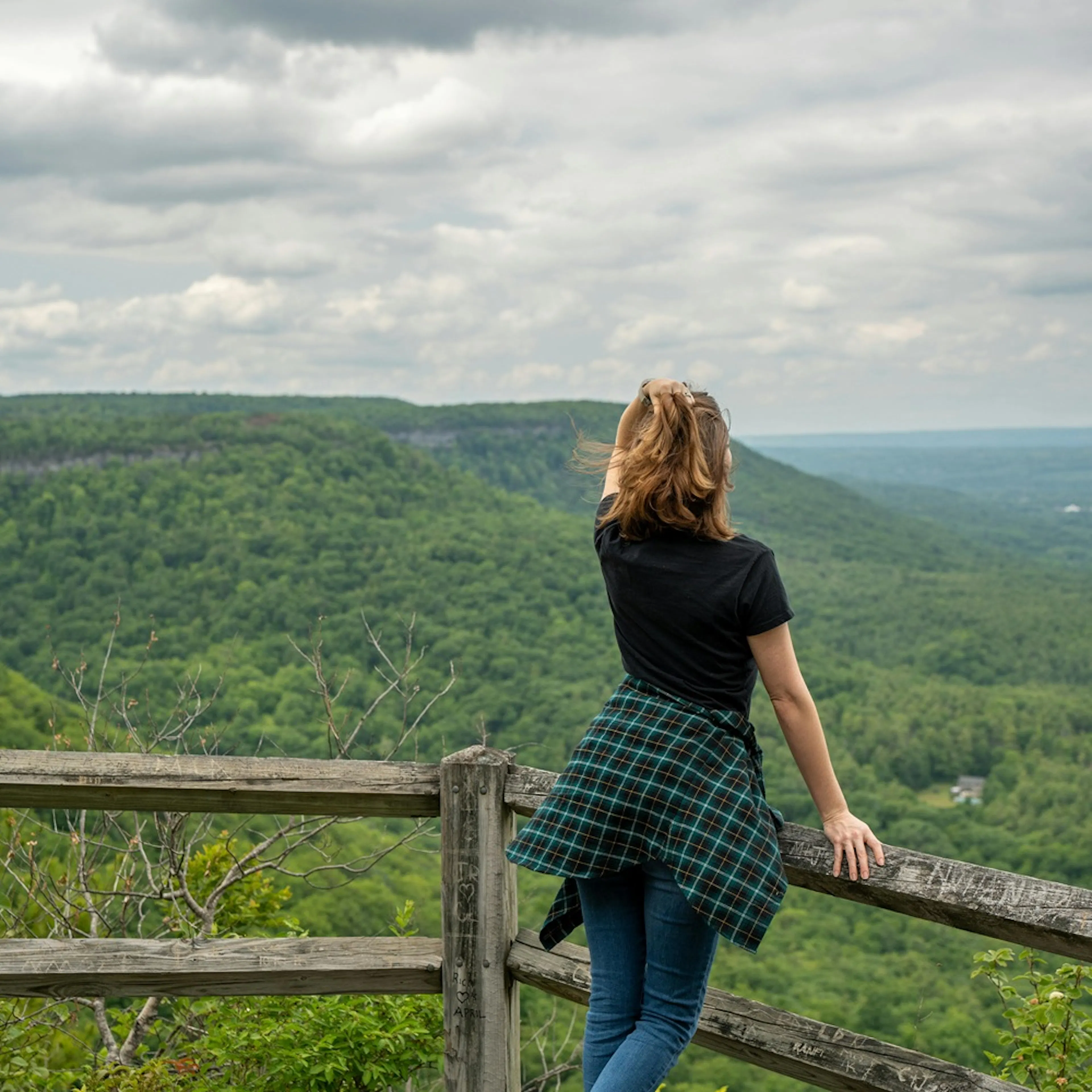 žena v přírodě, stojí na vyhlídce, kolem lesy