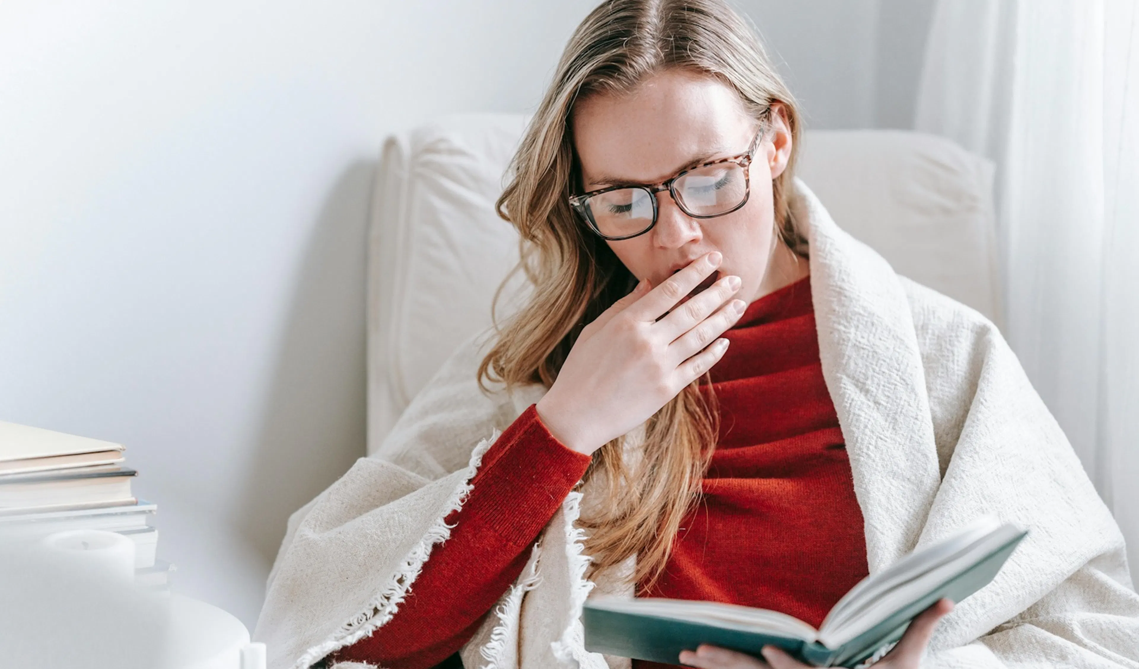 žena s knihou, čte a zívá u toho