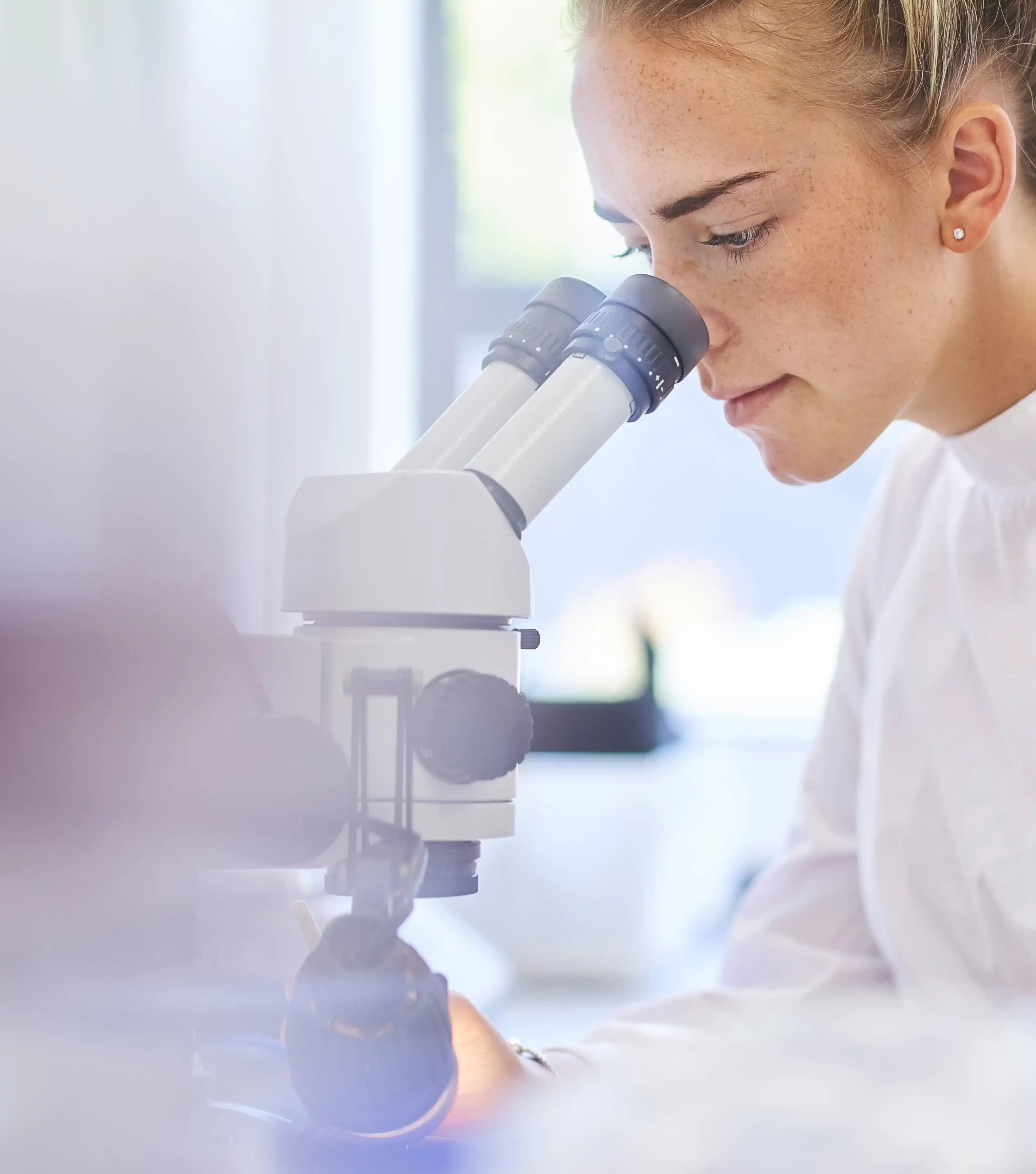 Femme qui regarde dans un microscope